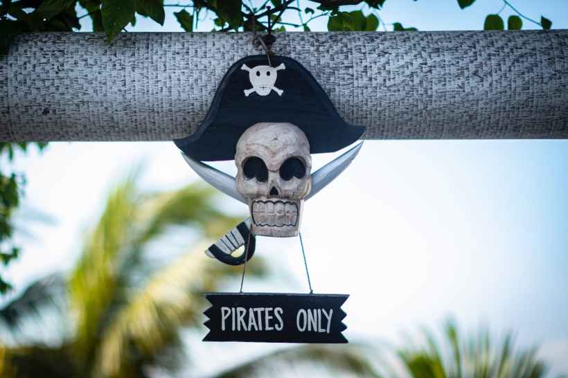 A sign shaped like a skull wearing a pirate hat and two swords that says "Pirates Only."