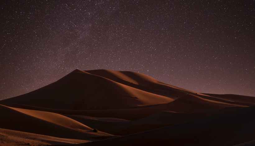 A sand dune at night.