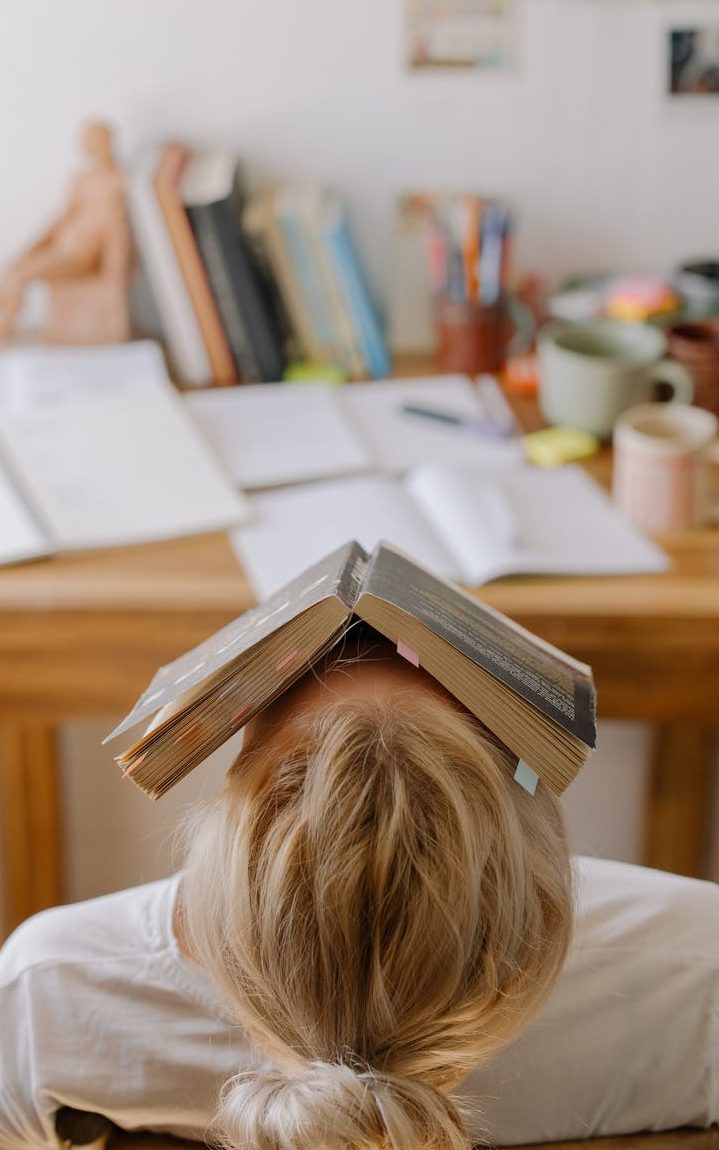A tired woman with a book over her face.