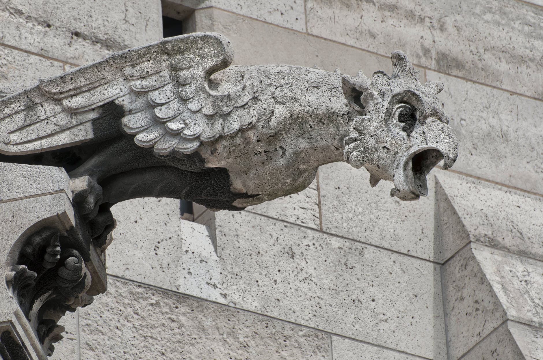 A birdlike gargoyle on an old building.
