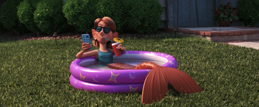 A scene from a movie "Onward". A mermaid in a kiddie pool with a drink with an umbrella in it, checking her cellphone.