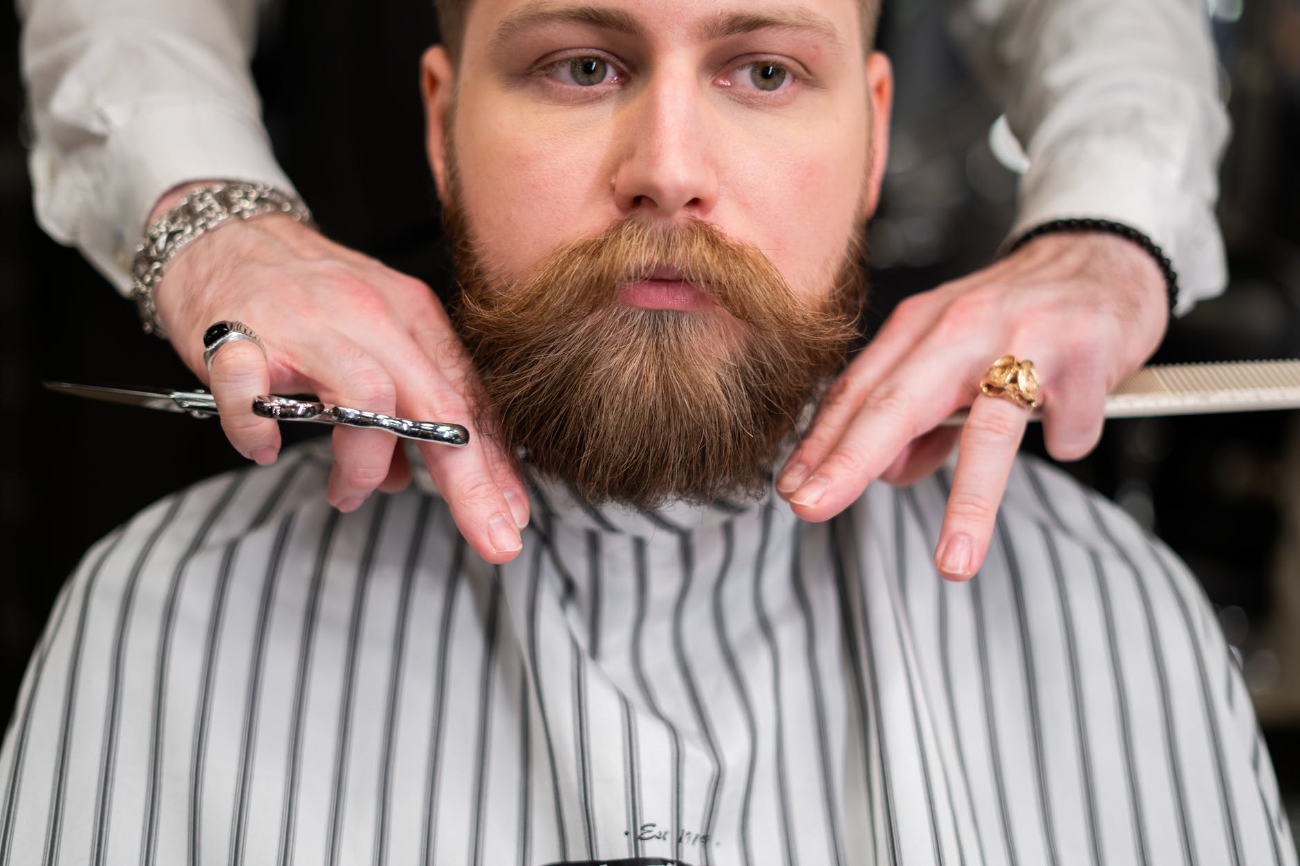 A man with a prominent moustache in a barber's chair.