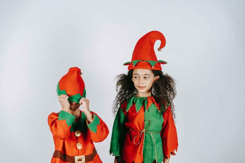 Two kids dressed as Christmas Elves.