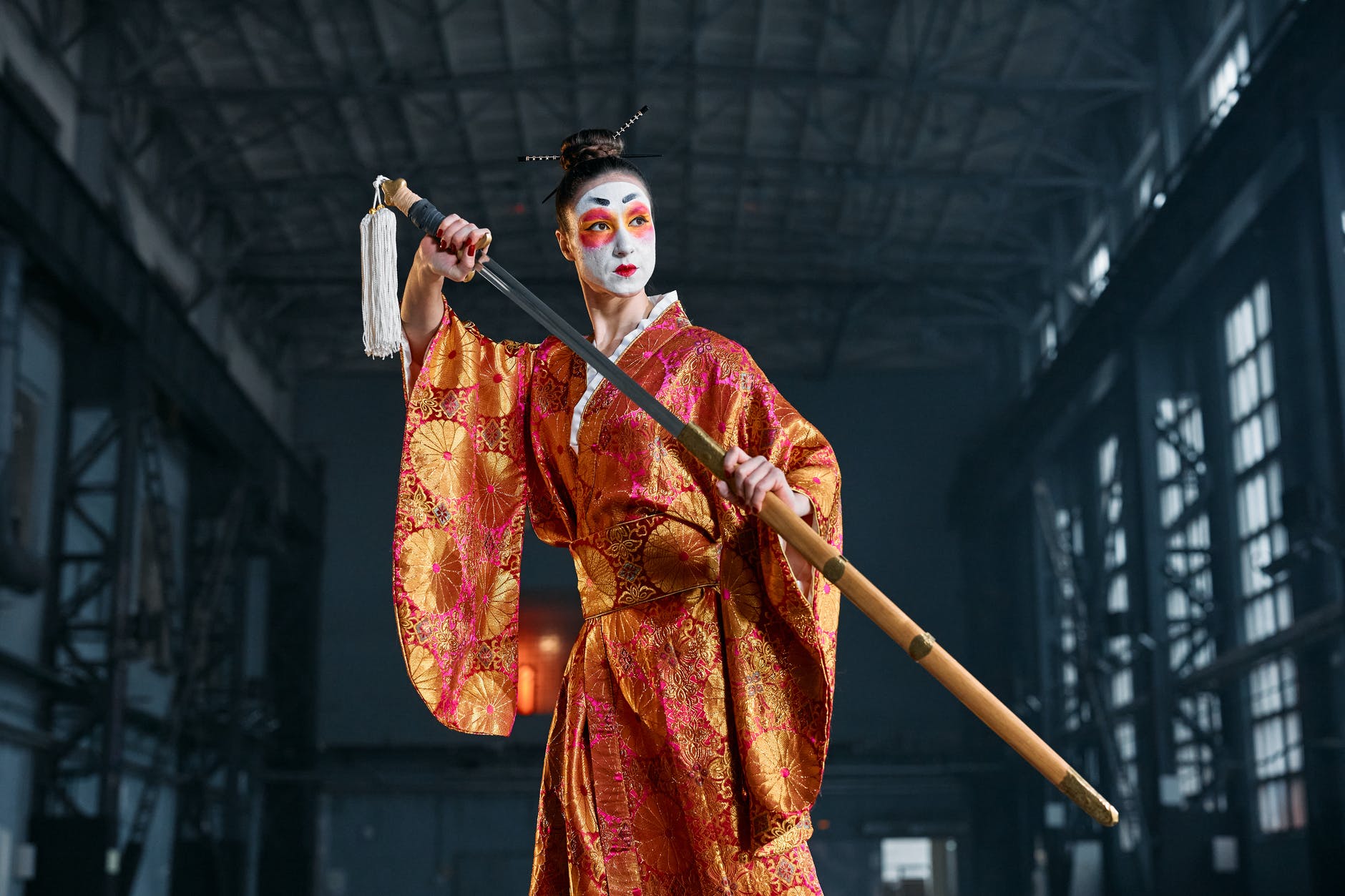 A woman dressed as a geisha, drawing a sword.