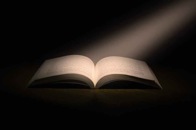 A beam of light fallin on an open book.