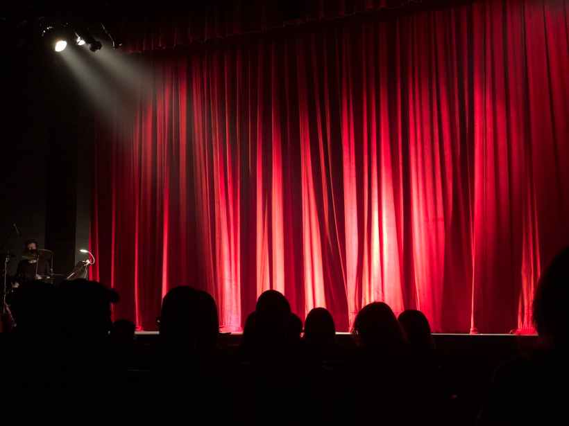People in front of a theatre stage.
