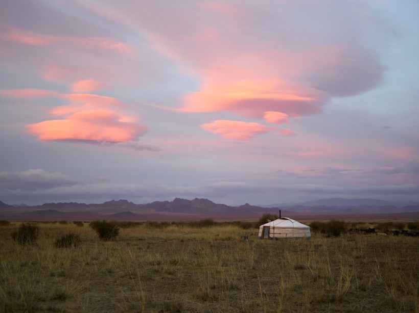 A yurt in the middle of an open plain.