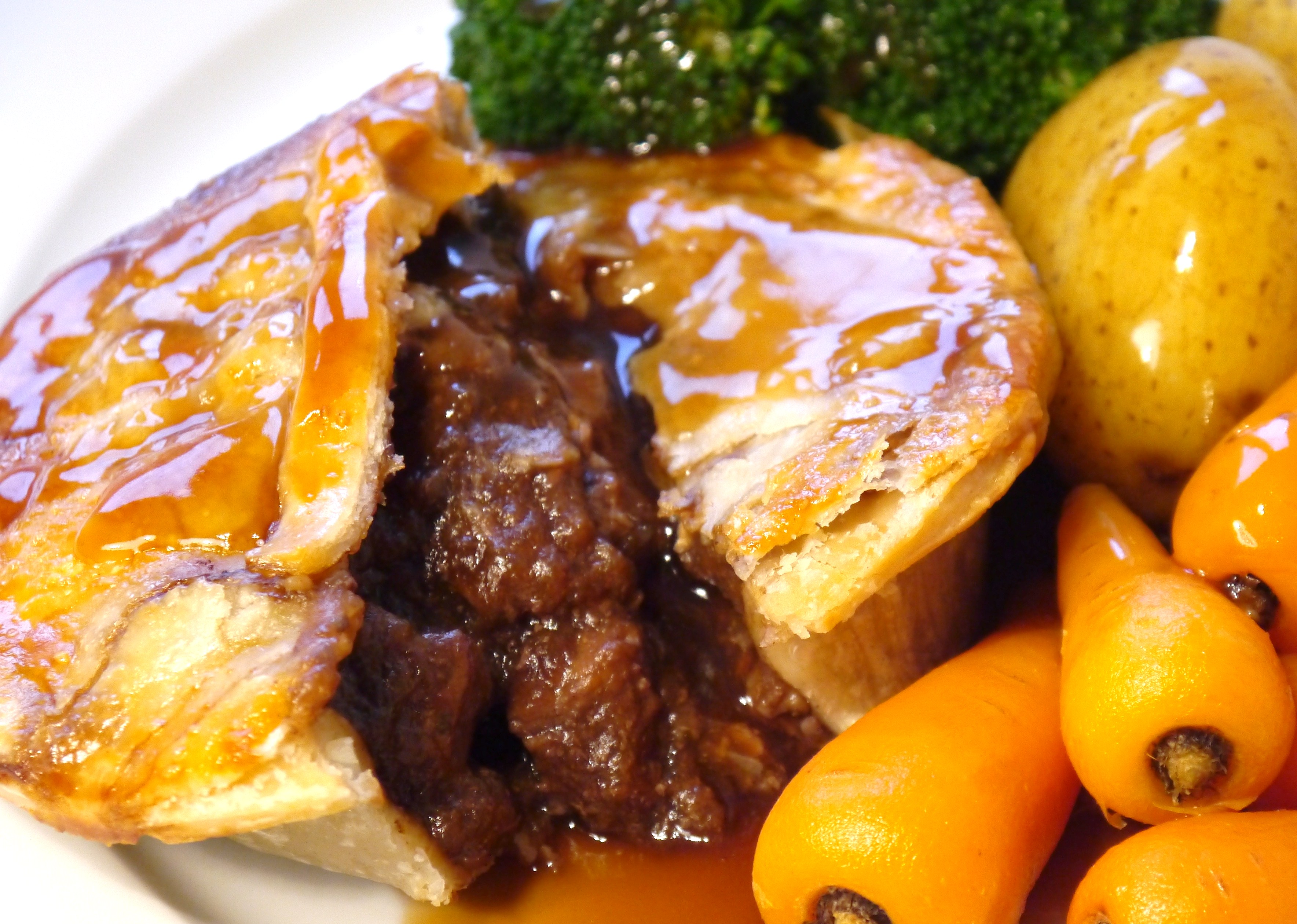 A steak pie with potatoes and vegetables.