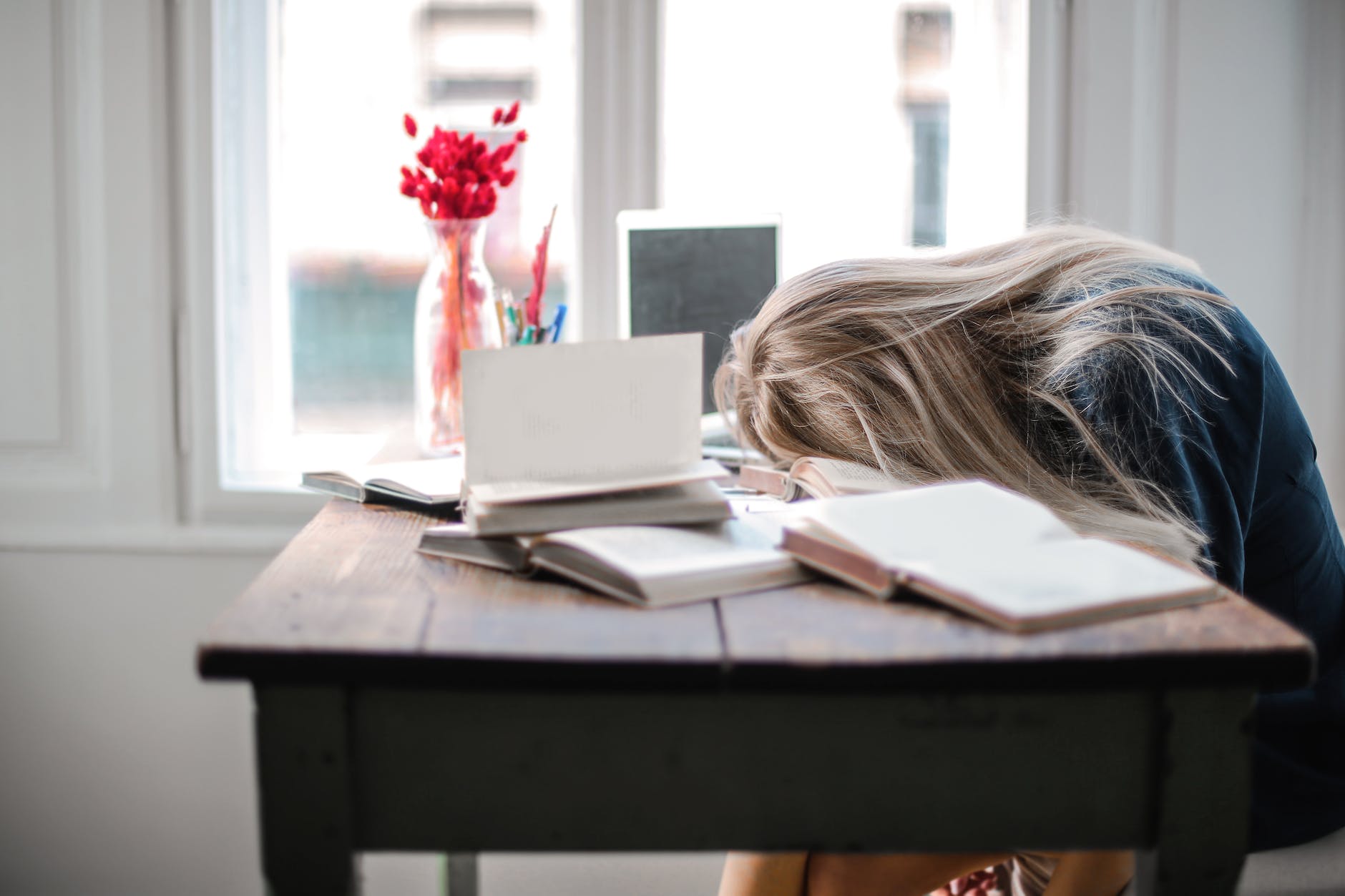A woman slumped over a desk in exhaustion.