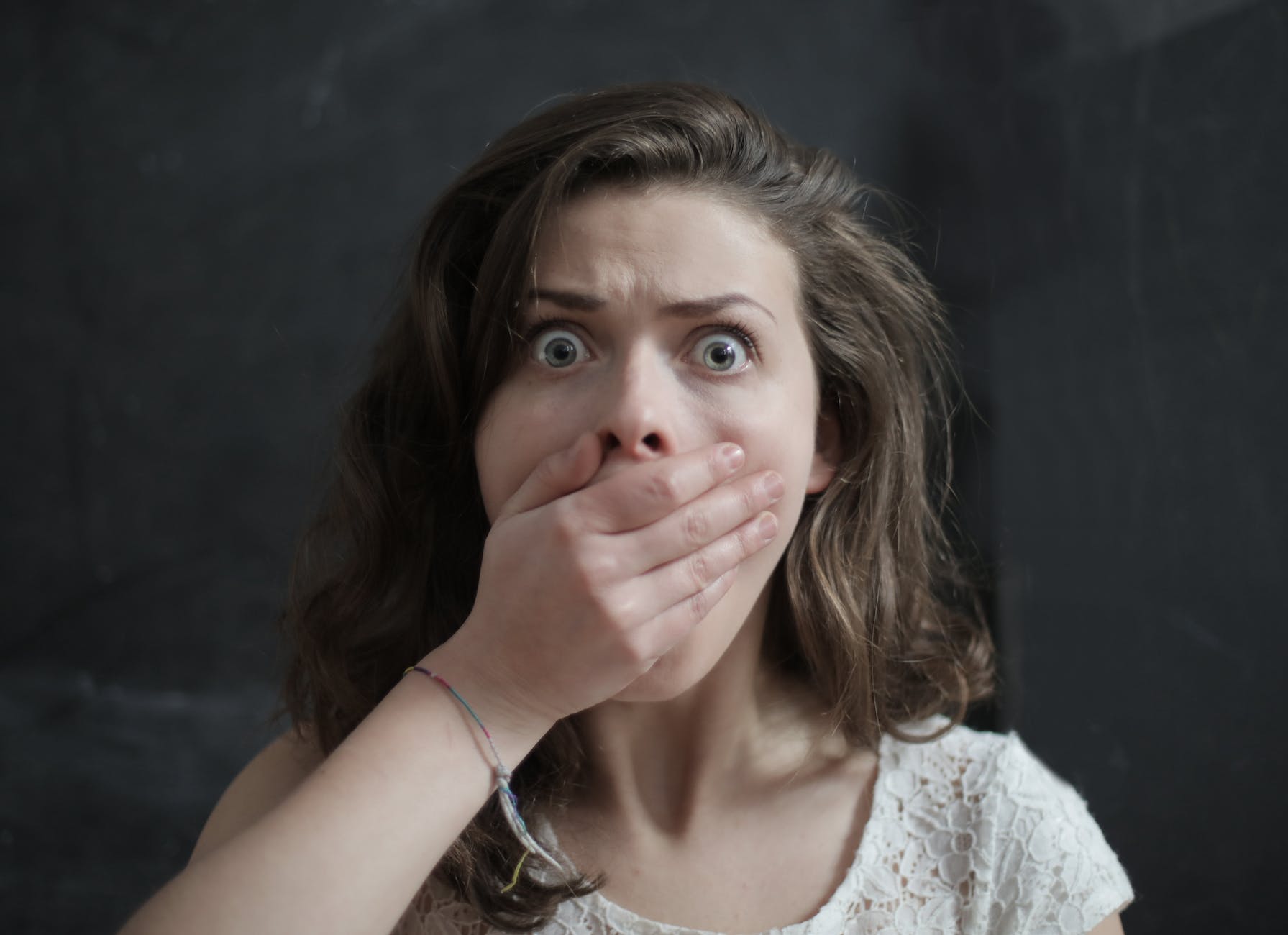 A woman covering her mouth in shock.