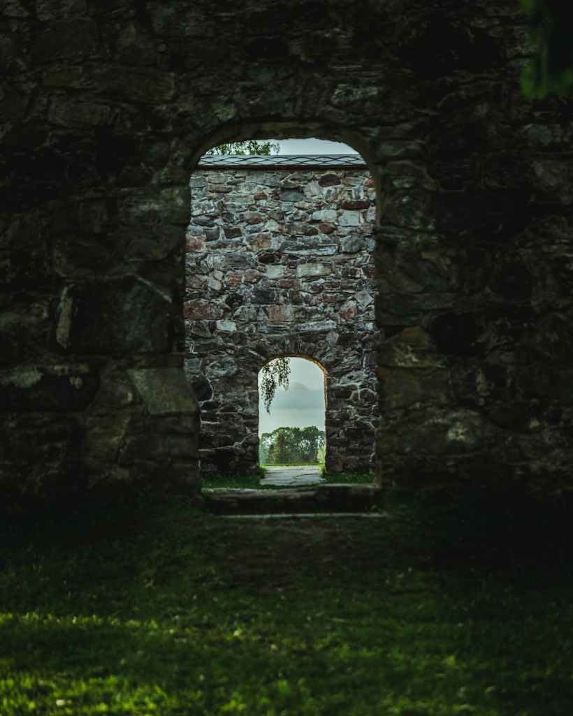 Looking through a doorway in a castle courtyard to another doorway.