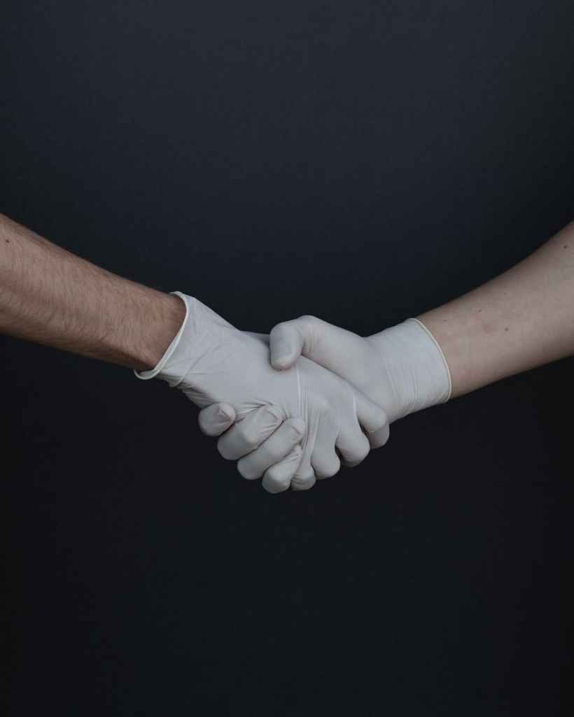 A handshake between two gloved hands.