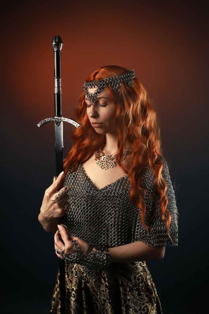 A woman in chainmail armour holding a sword.