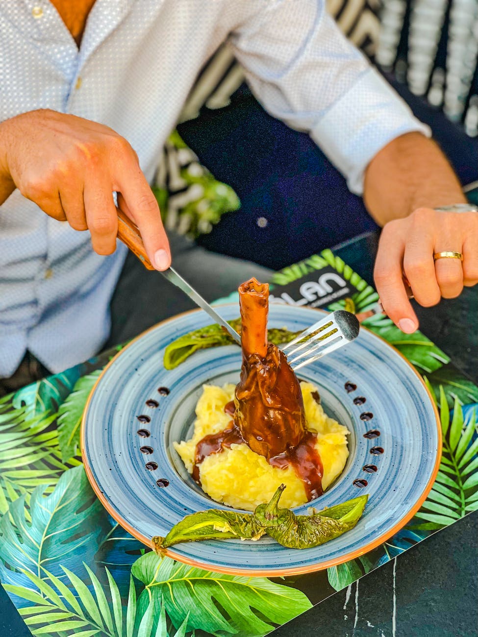 A man preparing to eat a shank of meat.