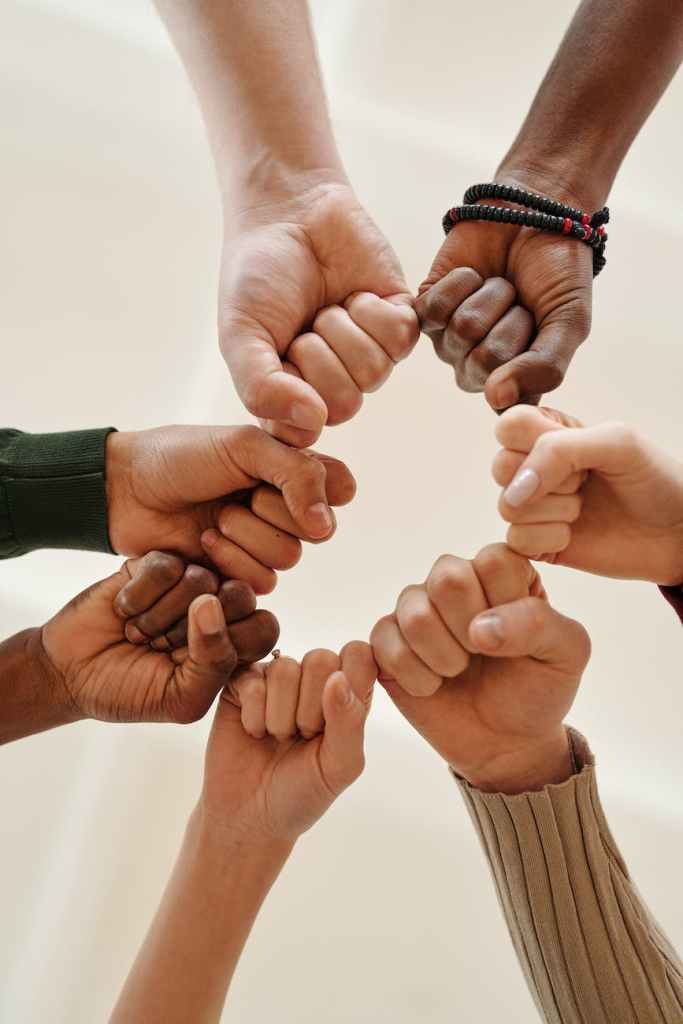 A group of people touching their fists together.