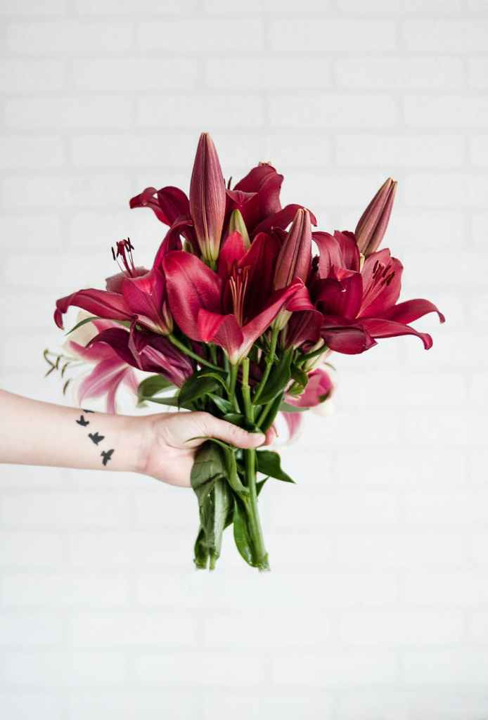 A hand holding a bouquet of flowers.