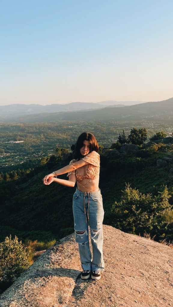 A woman photographed with a valley landscape in the background.