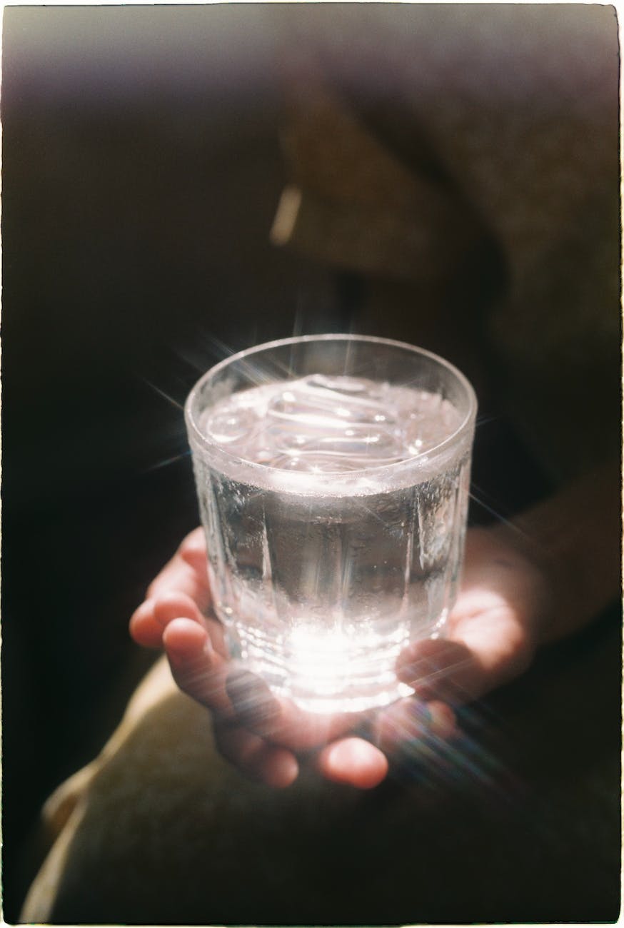 Hands holding a glass of water.