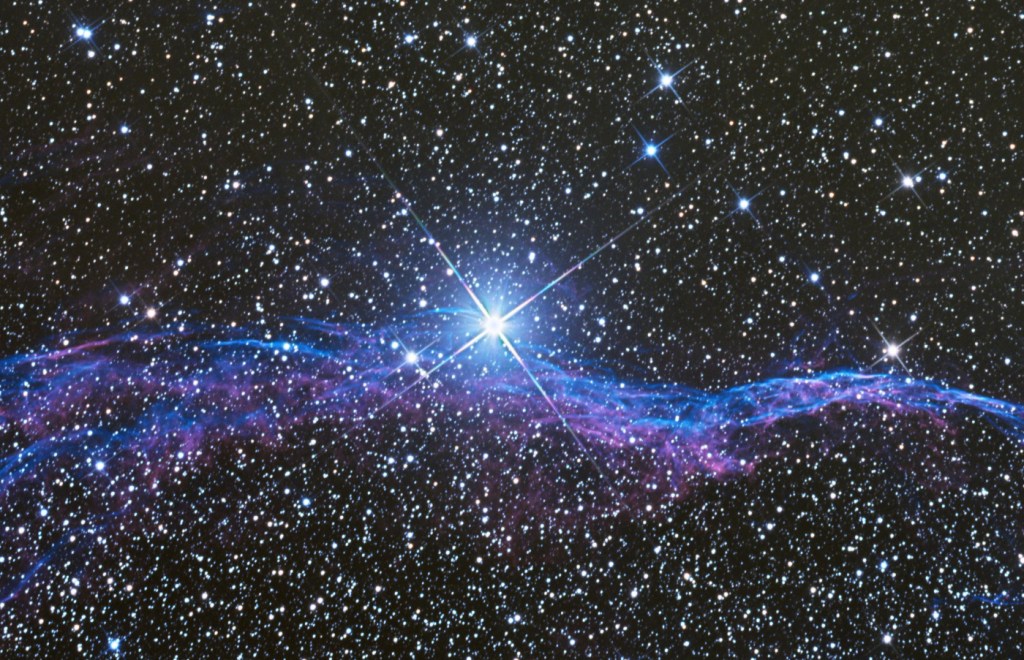 A field of stars, with one very bright star in the centre.