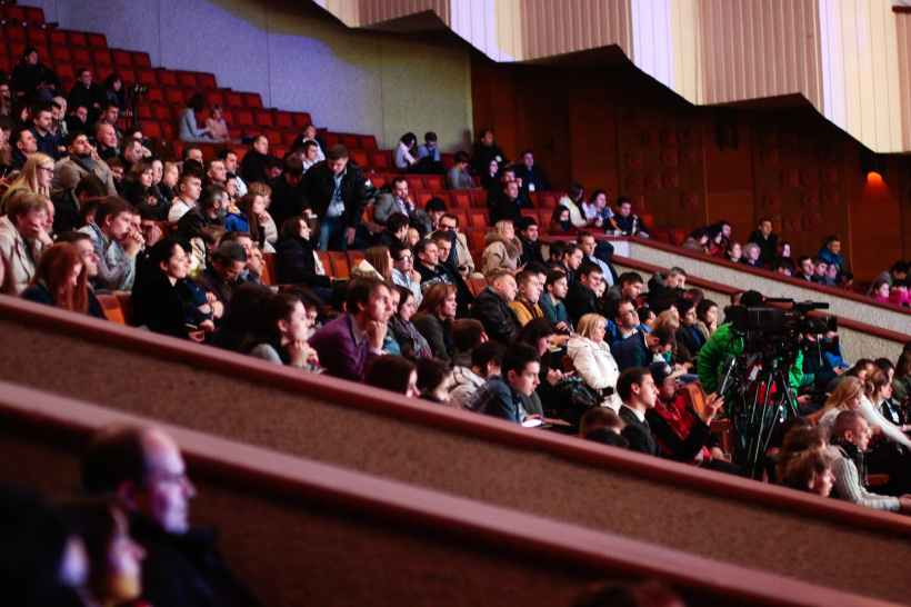 An audience of people on a theatre balcony.