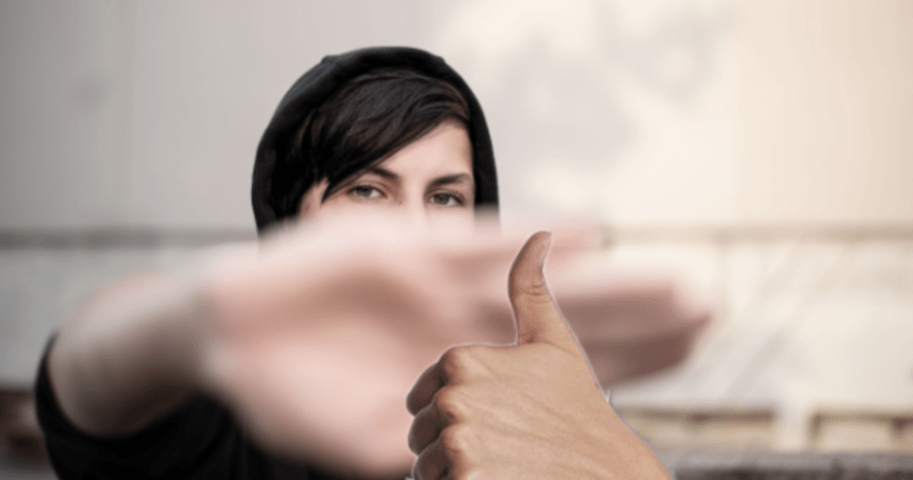 An edited image of a woman with a thumbs-up in front of her hand.