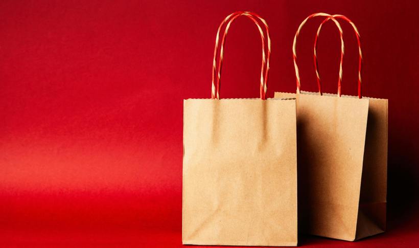 Two paper bags on a red background.