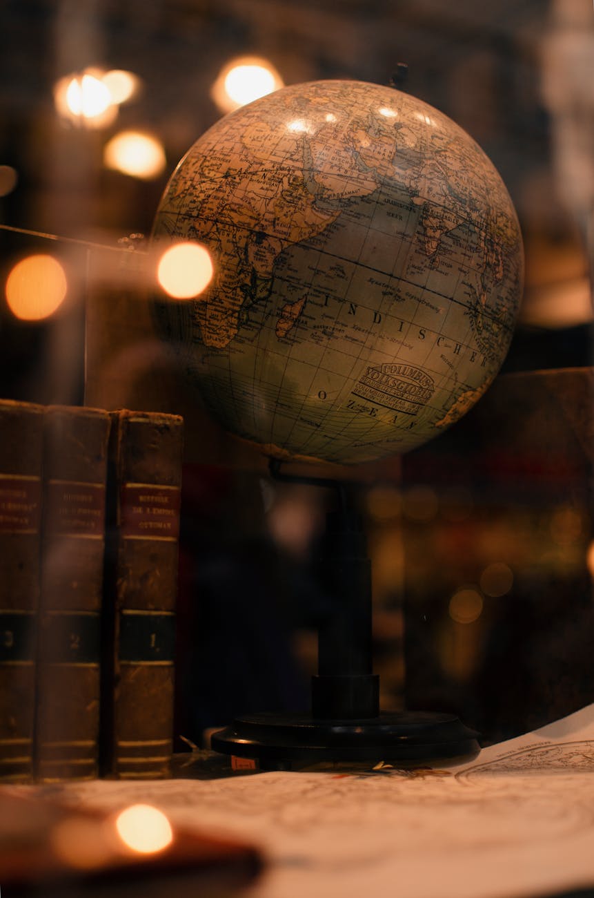 A globe and books on a desk.
