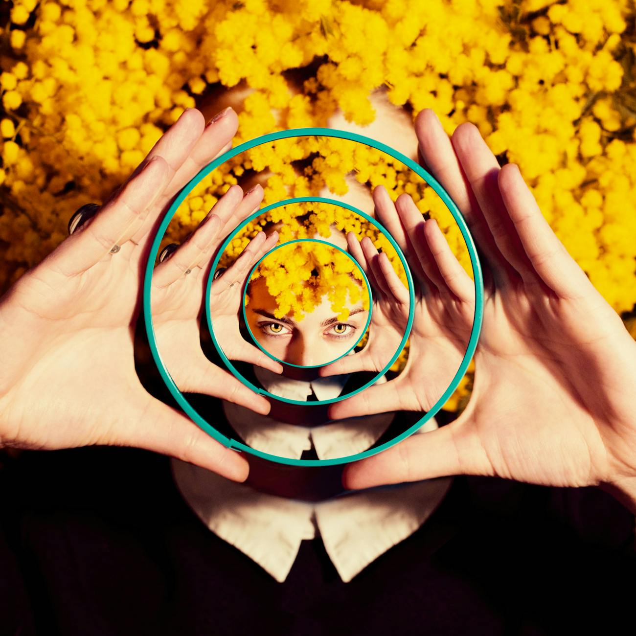 A woman holding a mirror reflecting the image of her holding the mirror.
