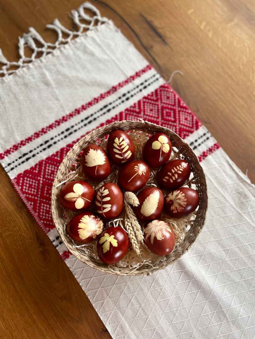 A basket of eggs on a tablecloth.