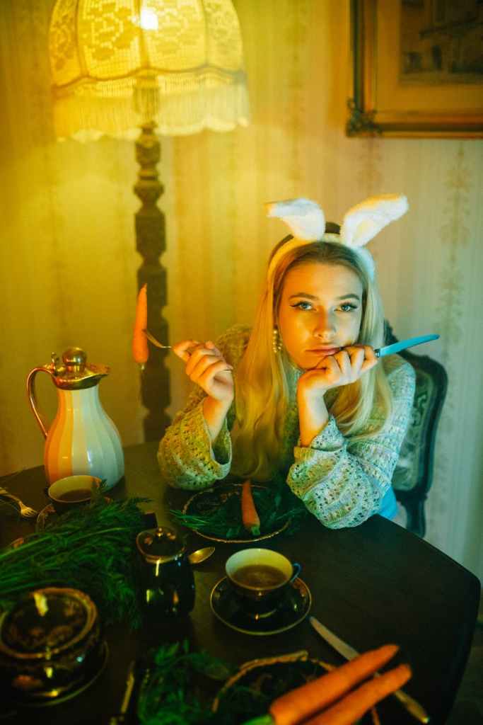A woman at a table with a bunny ear headband.