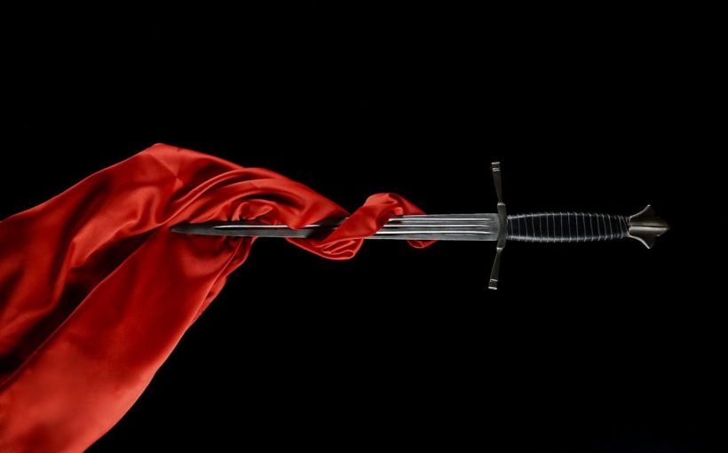A dagger with a red cloth wrapped around the blade.