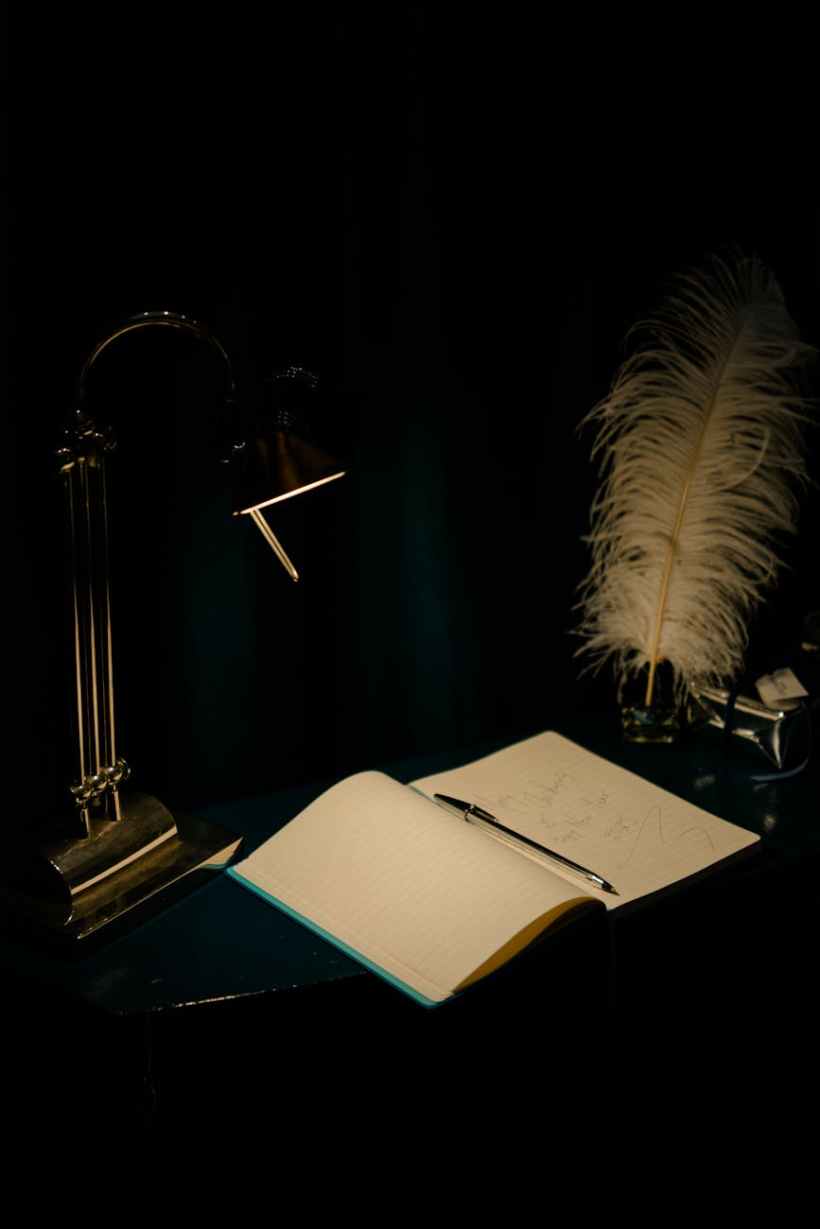 A book and a quill on a desk.