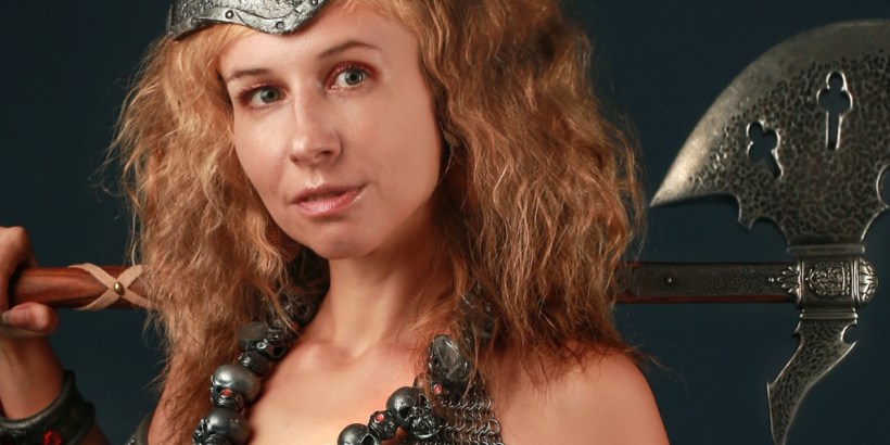 A red-haired woman with an axe over her shoulder.