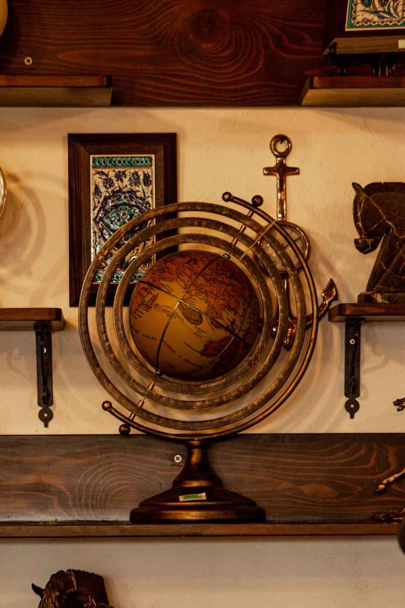 An antique globe and other items on a shelf.