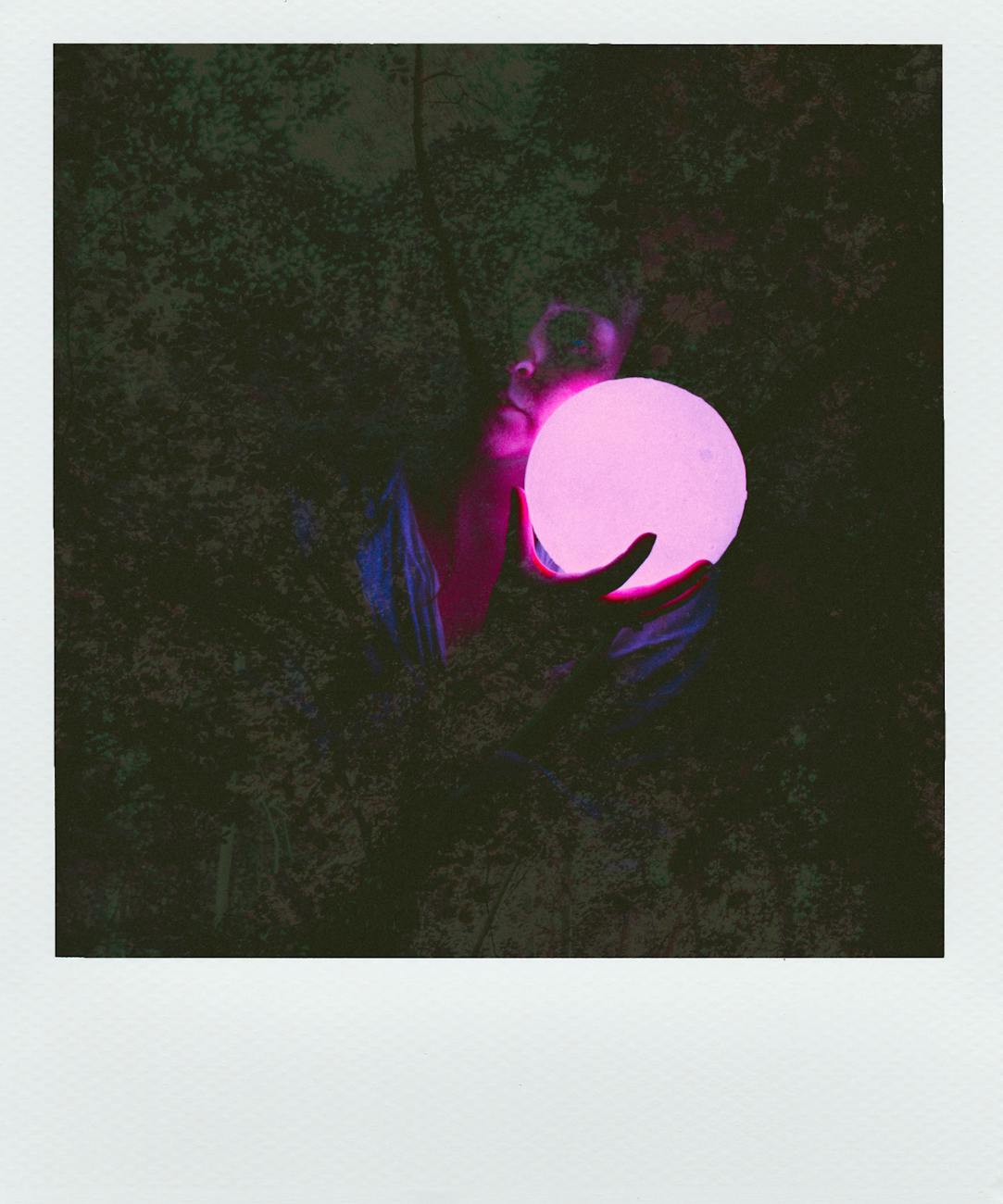 Hands holding a purple orb.