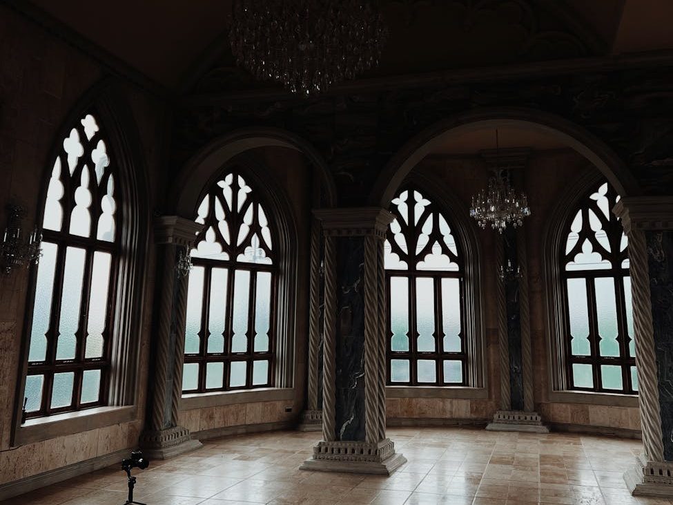 A room in a castle with large, ornate windows.
