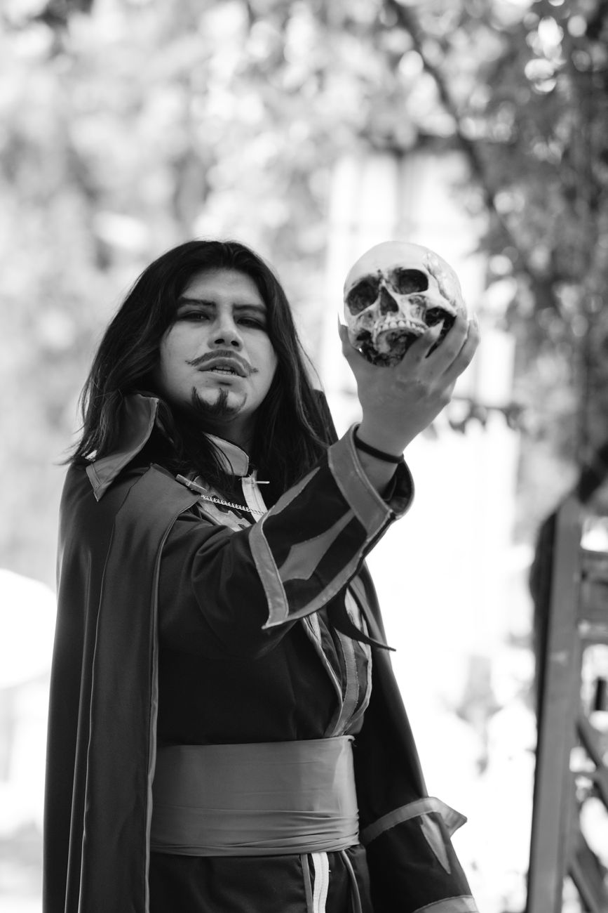 An actor holding a prop skull.