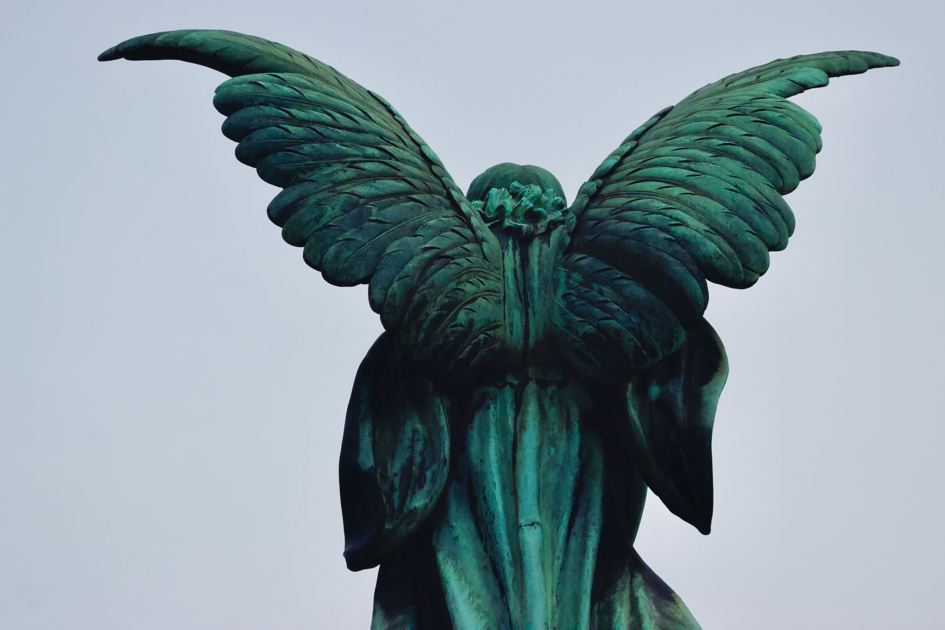 A bronze angel statue seen from behind.