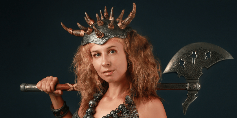 A woman in chainmail and a horned helmet with an axe.